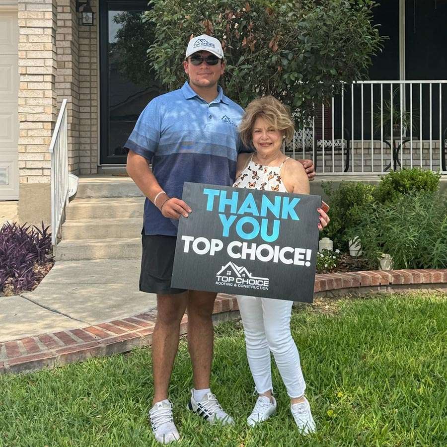 Happy customer with Top Choice Roofing sign