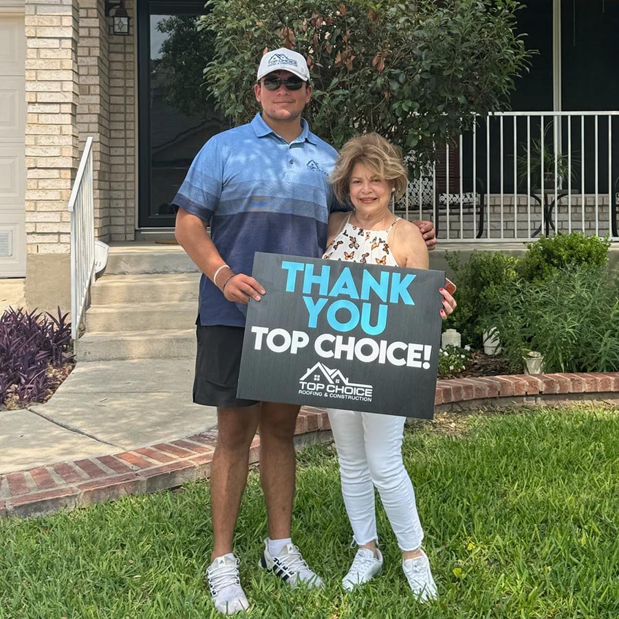 Happy customer with Top Choice Roofing sign